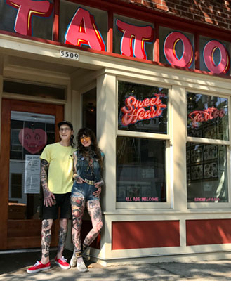 Sweethearts Joshua Bighaus and Jag Seyd stand in front of Sweet Heart Tattoo shop.